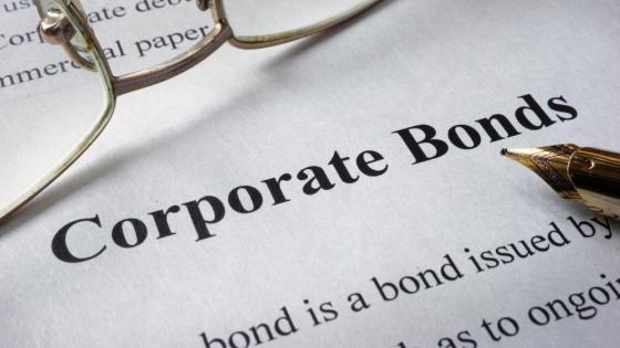 Glasses and a pen on top of a piece of paper that has the words Corporate Bonds