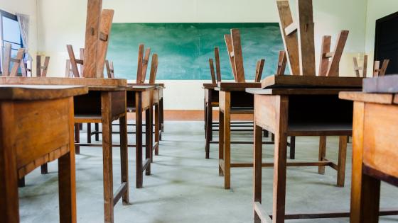 Empty classroom with upturned chairs on top of desks