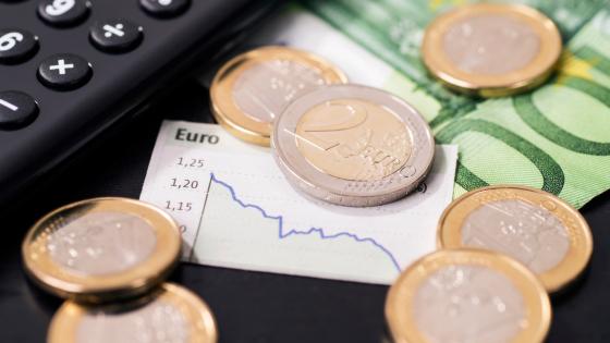 Euro coins, notes and chart showing weakening currency