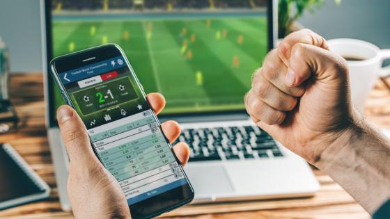 Man watching football and betting on phone