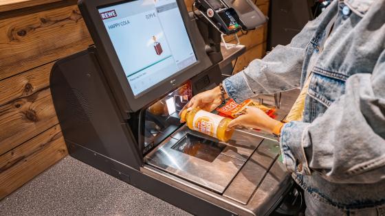 Customer scans a drink at supermarket self-checkout