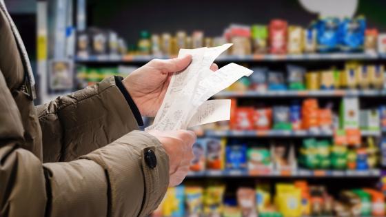 Man looking through receipt in supermarket