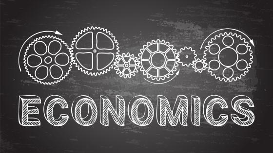 the word economics and cogs on blackboard