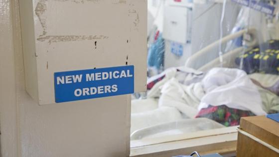 A box of 'new medical orders' stands in a hospital room