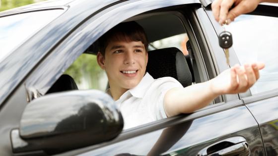 Young driver being given keys to car