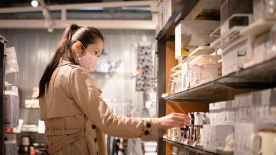 A woman wearing a facemask browses items in a shop in Japan