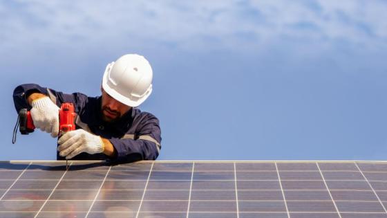 A labourer works on solar panels