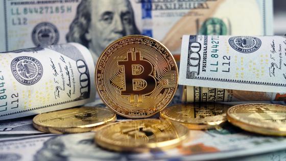 Close-up of bitcoin and dollar bills