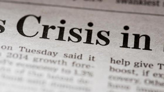 A newspaper snipped with the headline 'Crisis in'