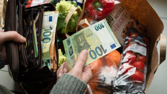 Woman taking euro bill out of purse to pay for shopping