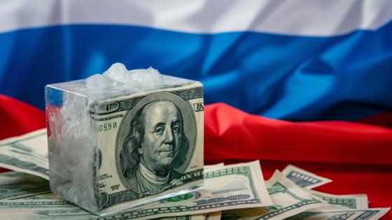 Photo of frozen dollars on the background of the Russian flag